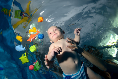 快乐宝贝婴儿游泳水下池中的包围玩具