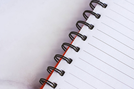 白色大理石背景的螺旋空白笔记本办公和学校用品概念