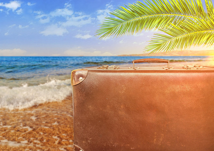 夏季旅游与旧行李箱与烈日的概念