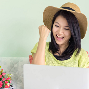 快乐的亚裔女子，和一台笔记本电脑