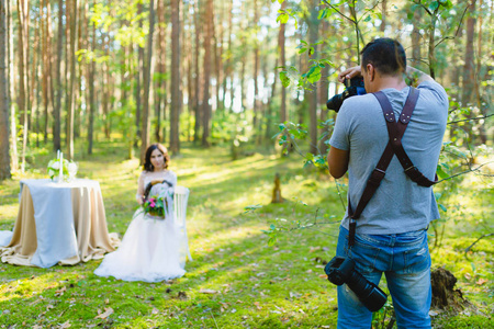 摄影师在森林里拍新娘的照片图片
