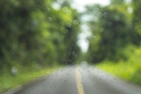 模糊公园与散景光一条长的路在雨天在自然背景下