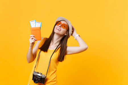 富有表现力的旅游妇女在夏季休闲服装, 帽子持有护照, 门票孤立黄色橙色背景。女性出国旅游周末出游。航空飞行旅途概念