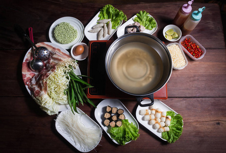 涮涮锅, 是猪肉牛肉虾鱿鱼海鲜和新鲜蔬菜的热门菜肴。放在桌上煮沸的锅