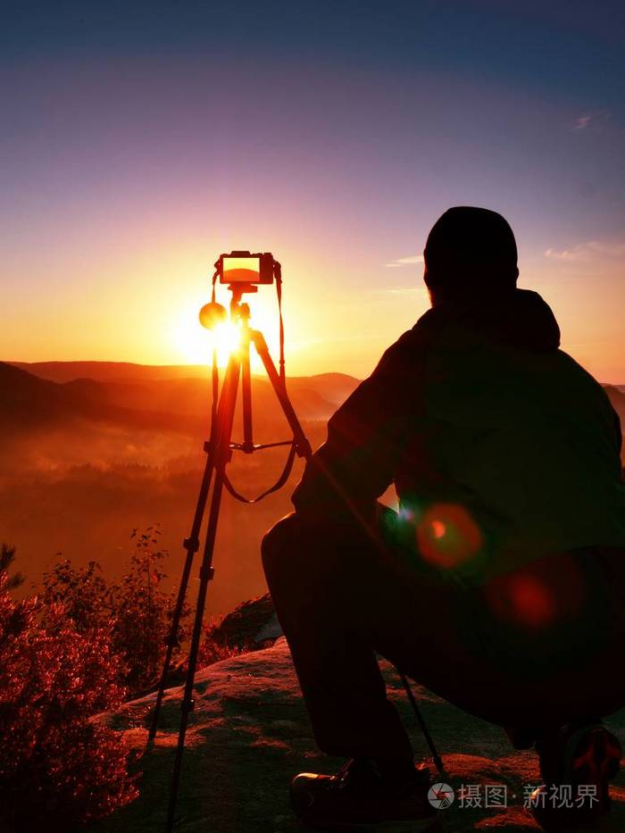 摄影师用相机的岩峰上拍照