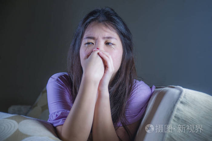 年轻的忧郁和沮丧的亚洲韩国妇女在家里沙发沙发哭绝望和无助的痛苦