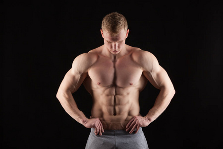 健壮的英俊男人健身模型展示六包 abs.孤立与 copyspace 的黑色背景上