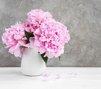 白色木桌上的粉红色牡丹花花瓶图片