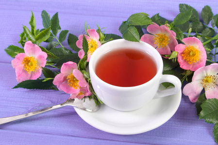 杯热茶和主板上的野生玫瑰花朵