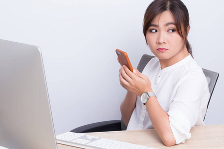 懒女人玩智能手机在办公室照片