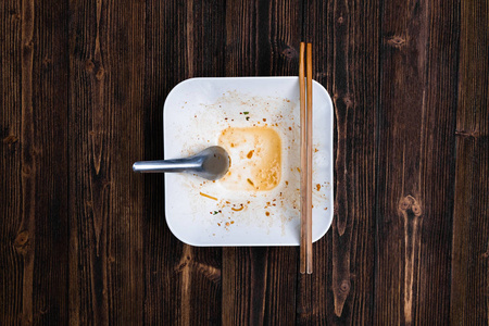 空的白色面条碗用勺子和筷子吃在木桌, 上部看法与拷贝空间为添加文本, 街道食物概念