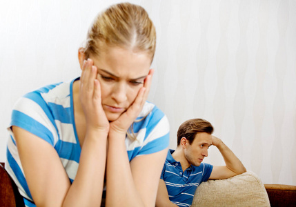 悲伤的夫妇不说话的战斗后,坐在沙发上照片