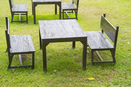 绿草背景下的黑色木桌和座椅