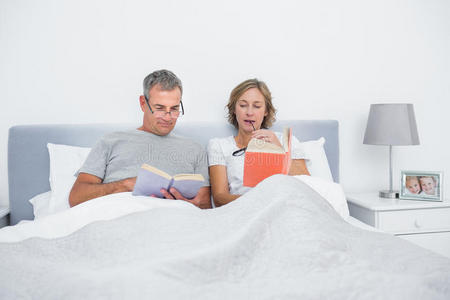坐在床上看书的幸福夫妻