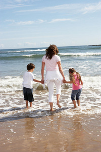 母亲和孩子们在海滩度假时玩得很开心