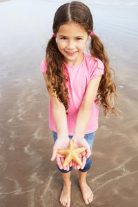 海滩上发现的抱海星的女孩