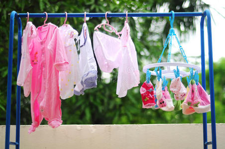 挂在晾衣绳上的粉色和彩色婴儿洗衣房