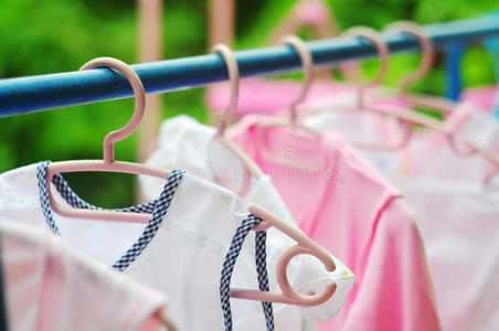 挂在晾衣绳上的粉色和彩色婴儿洗衣房