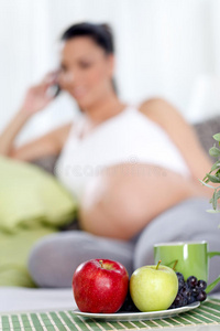 桌上有水果的孕妇