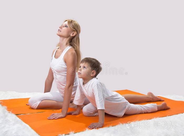 一位美丽的母亲和她的儿子练习瑜伽