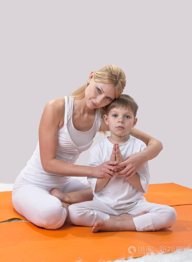 一位美丽的母亲和她的儿子练习瑜伽