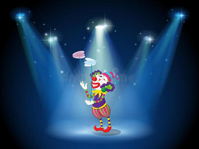 在聚光灯下在舞台上表演的小丑