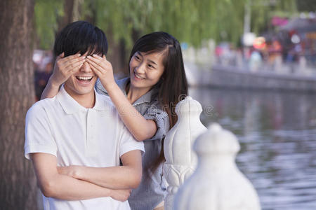 湖边遮住男人眼睛的女人图片