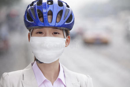 戴自行车头盔和面罩的年轻女商人