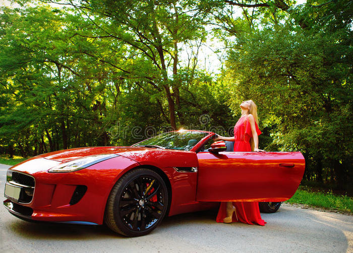 站在跑车旁的金发美女