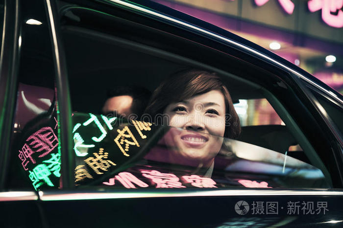 车窗摇下微笑的女商人望着北京的夜生活