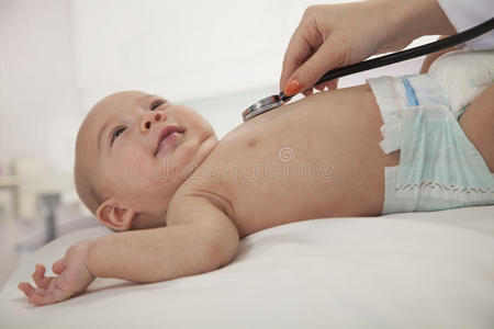 医生用手检查婴儿的心跳，特写