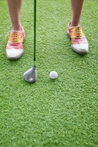 近距离的脚和高尔夫俱乐部准备打高尔夫球