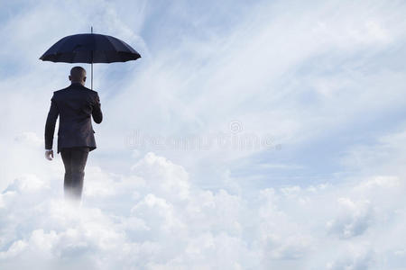 商人撑着雨伞，在梦幻般的云中漫步