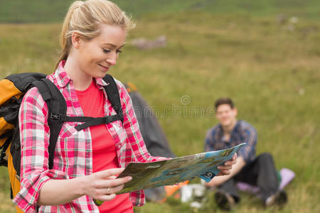 背着背包拿着地图的快乐女人