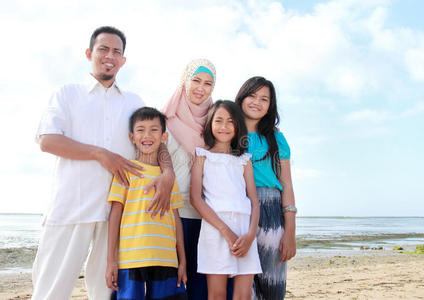 微笑幸福的亚洲家庭在沙滩上
