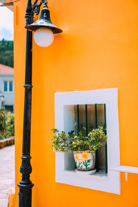 典型的希腊建筑细节概念。橙色房子墙壁, 花在罐子, 灯笼, 传统房子在希腊