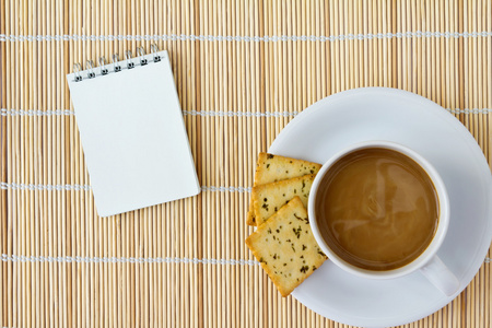 白陶瓷杯热的咖啡和白色速写，在垫子上的