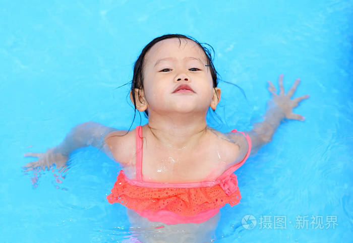 漂亮的小女孩在游泳池在户外玩耍