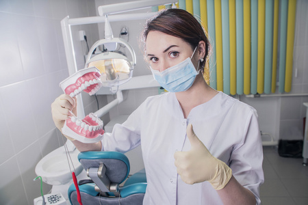 医用口罩和在医院工作的假牙的妇女牙医