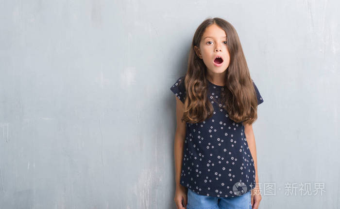 年轻的西班牙裔孩子在垃圾灰色墙壁害怕和震惊与惊喜的表情, 恐惧和