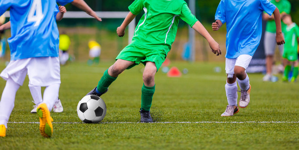 青年足球团队体育足球场上踢足球.年轻球员的足球比赛照片