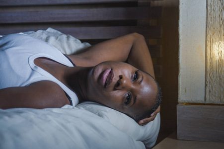 年轻的悲伤和沮丧的黑人非洲裔美国妇女在床上失眠深夜感到绝望焦虑和焦虑遭受抑郁症问题和失眠睡眠障碍