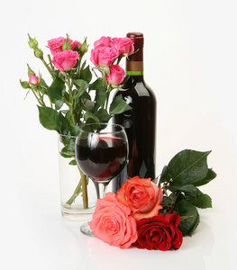 美丽的玫瑰和酒瓶的白色背景