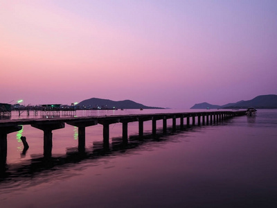 在泰国日出或日落背景的地方码头。在黄昏紫色的天空的木桥