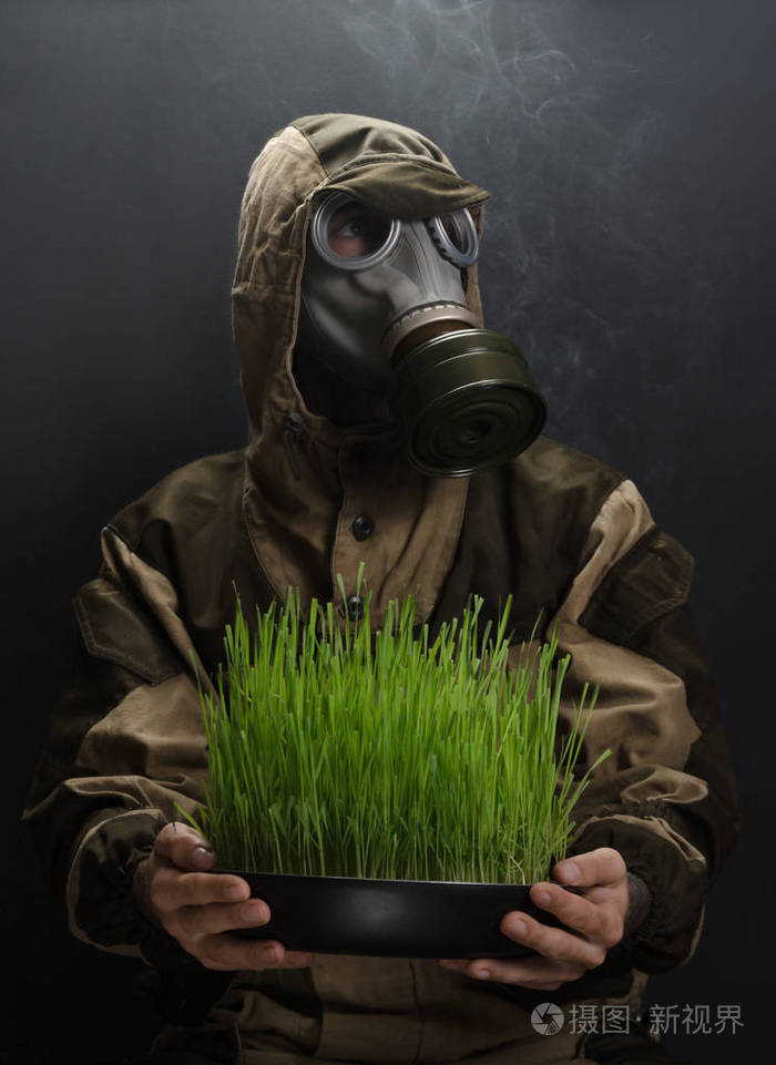 在灰色的背景上防毒面具的男子的图片