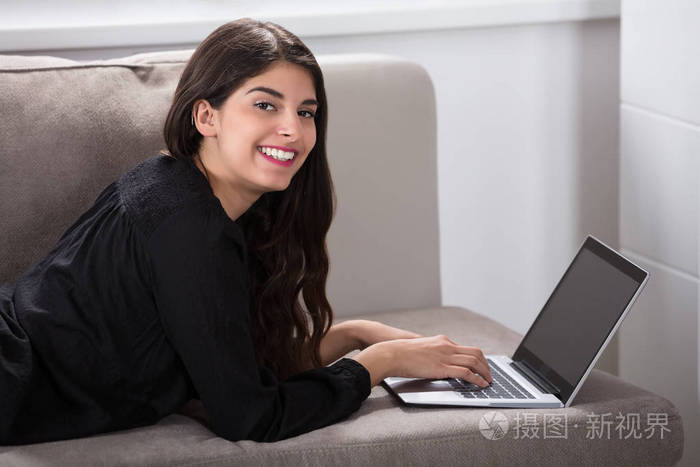 快乐的女人使用的便携式计算机