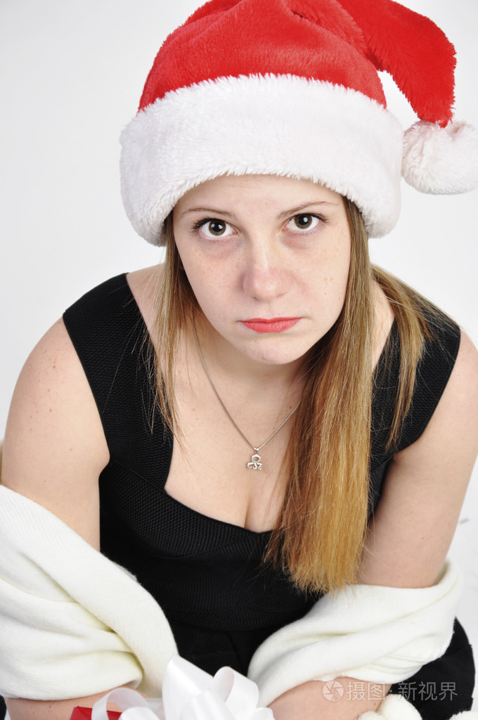 沮丧的年轻女孩在圣诞帽子的肖像