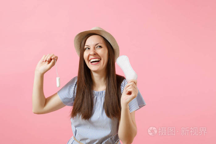 穿着蓝色衣服的年轻妇女的画像持有卫生巾卫生棉条为不同的安全月经日