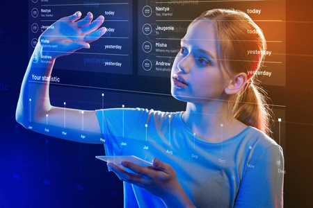 手持智能手机时, 细心的女孩触摸透明屏幕照片