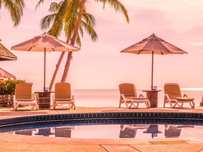 雨伞和椅子周围的豪华室外游泳池在酒店和度假村度假和旅游